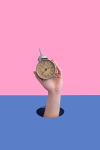 Hand holding a clock.