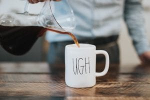 Pouring coffee into an ugh mug.